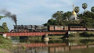 Dampfzug in Burma auf Brücke mit Pagode im Hintergrund