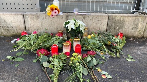 Blumen und Kerzen am Straßenrand