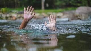 Zwei Hände strecken sich aus dem Wasser empor