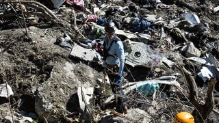 Mitglieder der französischen Gendarmerie untersuchen die Absturzstelle der Germanwings-Maschine in den französischen Alpen. Trümmerteile liegen überall im Gelände.