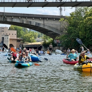 Demonstrierende mit Stand-Up-Paddles und Kanus auf dem Neckar in Stuttgart. Sie setzen sich für ein Ende des Badeverbots ein.