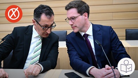 Links sitzt Cem Özdemir von den Grünen. Neben ihm sitzt Manuel Hagel von der CDU. Die beiden reden miteinander. Rechts das SWR Logo für Leichte Sprache. Links oben ein roter Kreis mit einem weißen Kreuz.