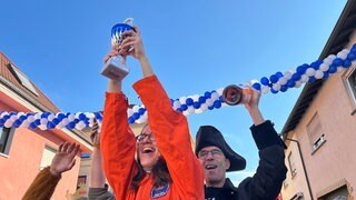 Auf dem Siegertreppchen strecken die Zweitplatzierten ihre Trophäe in die Luft