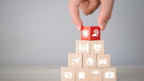 Würfel-Pyramide mit verschiedenen Symbolen für Versicherungen