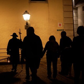 Eine Gruppe bei Nacht mit einem Nachtwächter unterwegs. Heinz-Dieter Wettki hält die Tradition in Mühlheim am Leben.