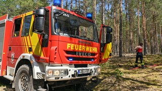 Löschfahrzeug der Feuerwehr in einem Kiefernwald bei Wünsdorf: Waldbrände nehmen weltweit zu, auch in Deutschland. Kurzfristig können bessere Frühwarnung und Löscheinsätze helfen, langfristig nur der Waldumbau mit Bäumen, die dem Feuer besser widerstehen.