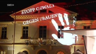'Stopp Gewalt gegen Frauen' an eine Hauswand projiziert