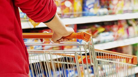 Person schiebt ihren Einkaufswagen durch die Gänge eines Supermarktes.