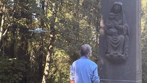 Norbert Scheuer am Gedenkkreuz auf dem Kalvarienberg in Prüm, das an die Katastrophe von 1949 erinnert.
