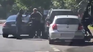 Auf dem Video ist zu sehen, wie ein maskierter Mann einen anderen mit einer Pistole bedroht. 