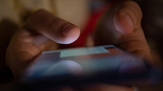 Handy die auf ein Handy-Display tippen. In Chatgruppen und Internet-Foren radikalisieren sich sogenannte Attentäter-Fans.