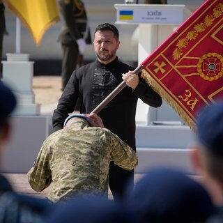 Wolodymyr Selenskyj übergibt die Fahne einer ukrainischen Militäreinheit