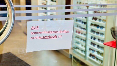 An einer Geschäftstür hängt ein Schild, dass alle Sonnenfinsternis-Brillen ausverkauft sind. 