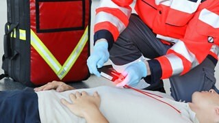 Eine Rettungskraft legt bei der Triage einem Patient den von ZF entwickelten "Life-TAG" um den Hals. 