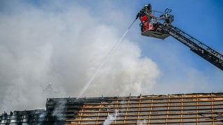 Einsatzkräfte der Feuerwehr bekämpfen das Feuer in einem Dachstuhl in der Schwäbisch Gmünder Innenstadt. 