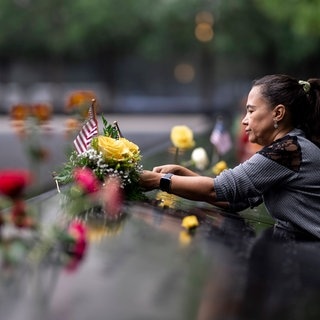 Eine Frau legt Blumen an der Gedenkstätte des Anschlags des 11. September 2001 nieder. 