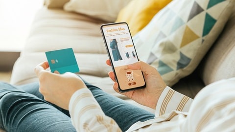 Frau kauft über Internetshop ein Kleid