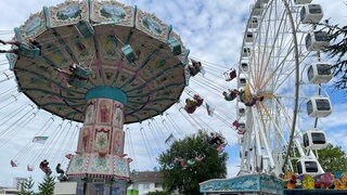 Das Kettenkarussell und das Riesenrad auf dem Festgelände des Seehasenfestes in Friedrichshafen sind zu sehen.