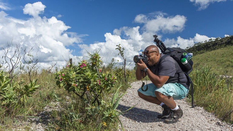 Tourist fotografiert Pflanzen: Eine Strategie zur Erhaltung des Cerrado und seiner Bevölkerung ist ein nachhaltiger Tourismus. Er schafft Einkommensmöglichkeiten und die Bevölkerung in der Parkumgebung hat wirtschaftliches Interesse an der Erhaltung der Natur.