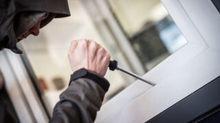 Ein Einbrecher hebelt ein Fenster auf (Symbolbild): In Speyer wird pro Einwohner am häufigsten in Rheinland-Pfalz eingebrochen.