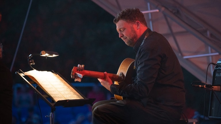 Musiker spielt Gitarre auf der Bühne
