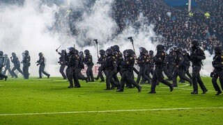 Polizisten stürmen auf den Rasen im Stadion von Waldhof Mannheim