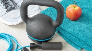 Sportschuhe, ein Springseil, eine Hantel und ein Apfel liegen nebeneinander | Gute Vorsätze sind oft zu groß | Neujahrsvorsätze: Mit realistischen Zielen motiviert ins neue Jahr