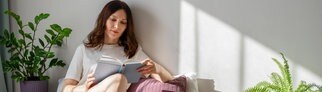 Eine junge Frau liest ein Buch | Trend aus Japan: Wie Romane uns heilen können