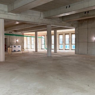 Ein leerer Raum in einem Rohbau der neuen Anna Seghers-Bücherei in Mainz, Boden und Wände sind aus grauem Beton.