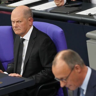 Bundeskanzle Olaf Scholz (SPD) (oben) und Friedrich Merz, CDU-Vorsitzender und Vorsitzender der CDUCSU-Bundestagsfraktion. Der Bundestag stimmt für Unionsantrag zur Migration