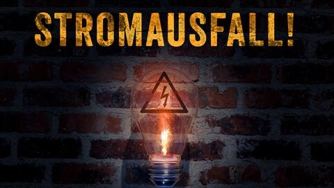 Stromausfall: Eine funkende defekte Glühbirne vor einer dunklen Wand.