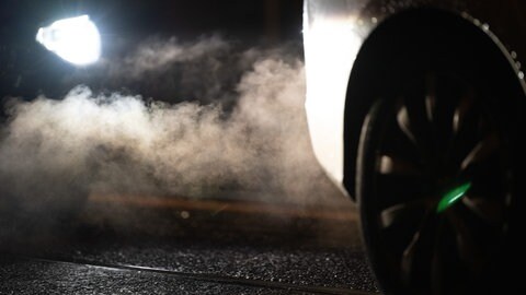 Abgase kommen aus dem Auspuff eines Autos. Werde der Straßenverkehr nicht deutlich verringert, werden die Klimaziele laut Klima-Sachverständigenrat nicht erreicht.