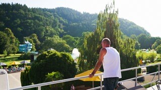 Michael Lorenz steht auf dem Balkon seiner Wohnung im Strandbad Freiburg und schaut in die Ferne über das Gelände.