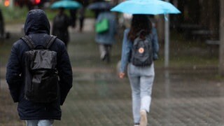 Menschen laufen im Regen durch die Stadt. Für die kommenden Tage erwartet der Deutsche Wetterdienst in Baden-Württemberg Dauerregen. (Symbolbild)