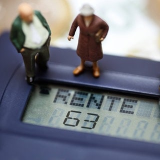 Miniaturfiguren von Senioren auf einem Taschenrechner mit dem Schriftzug "Rente 63".
