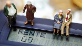Miniaturfiguren von Senioren auf einem Taschenrechner mit dem Schriftzug "Rente 63".