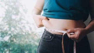 Frau misst ihren Bauchumfang nach