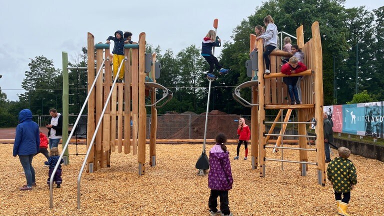 Kinder klettern auf einem Klettergerüst - Der Unisport der Rheinland-Pfälzischen Technischen Universität Kaiserslautern-Landau (RPTU) hat auf dem Campus einen Abenteuerspielplatz eröffnet. Das Kitz-Land können Kinder mit einer Unisport-Karte besuchen.