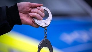 Polizist mit Handschellen (Symbolbild)