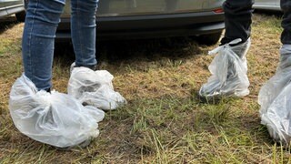 Füße stecken in Plastiktüten - Regenschutz bei Rock am Ring
