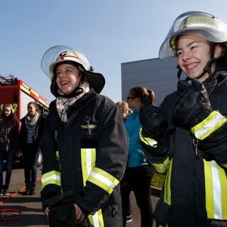 Auf dem Foto sind Mädchen zu sehen, die an einem Girlsday den Beruf der Feuerwehrfrau kennenlernen.