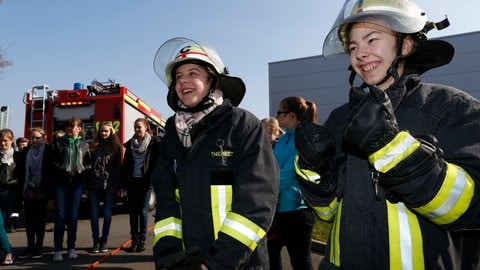 Auf dem Foto sind Mädchen zu sehen, die an einem Girlsday den Beruf der Feuerwehrfrau kennenlernen.