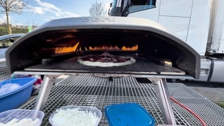 In einem mobilen Ofen liegt eine Pizza. 