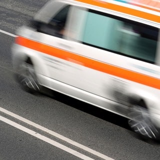 Der betrunkene Lkw-Fahrer von der Raststätte bei Waldmohr ist jetzt in eine Krankenhaus gebracht worden (Ein Krankenwagen verlässt eine Unfallstelle auf einer Autobahn).