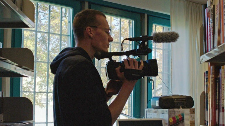 Protagonist Björn filmt in Bücherei der JVA