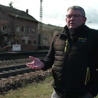 Der Bürgermeister von Bengel, Karl-Josef Simon, steht vor dem alten Bahnhof der Gemeinde. Das Gebäude wird zum Lost place und verfällt,deshalb wird ein Käufer gesucht, der sich um den Abriss oder Umbau kümmert.