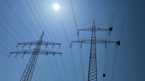 Strommasten in der Landschaft. Die norddeutschen Bundesländer fordern unterschiedliche Strompreiszonen in Deutschland. Das könnte den Strom im Süden teurer machen.