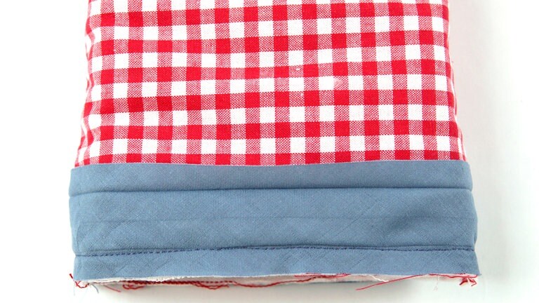 Das Schrägband 1 mm rechts von der ersten Umbruchkante feststeppen.