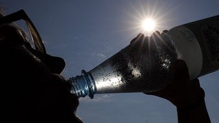 Eine Frau trinkt in der Sonne Mineralwasser. (zu dpa: «Hitzewarnung und Unwetter in Nordrhein-Westfalen»)