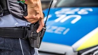 Ein Polizist mit der Hand an der Waffe. Wie gut ist die Polizei auf den Umgang mit Menschen in psychischen Krisen vorbereitet?